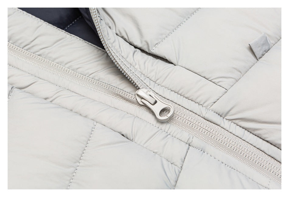 Close-up of the light gray quilted jacket's front zipper and large matching zipper pull.
