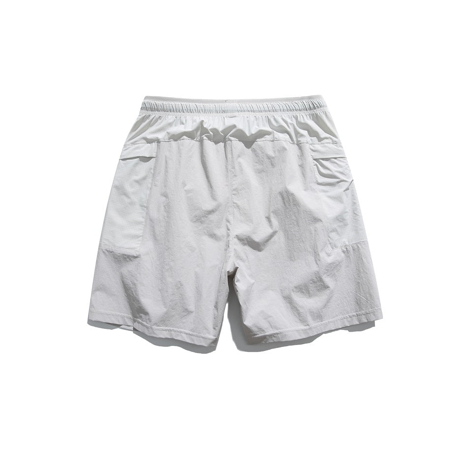 Back view of white shorts laid flat, with an elastic waistband and large panel pockets.