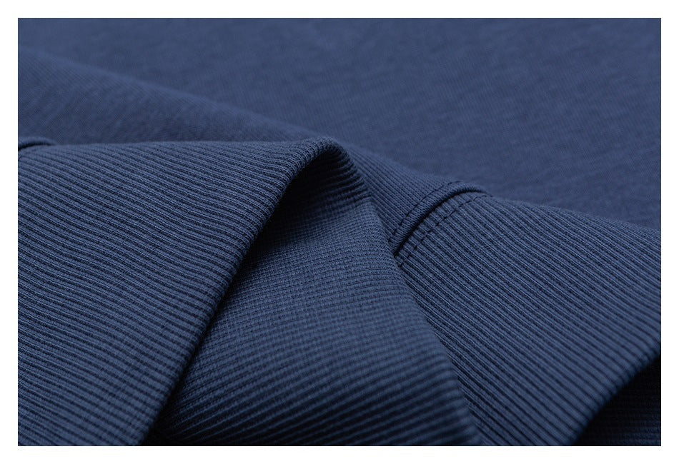 Close-up of dark navy ribbed fabric with a folded edge and stitched seam.