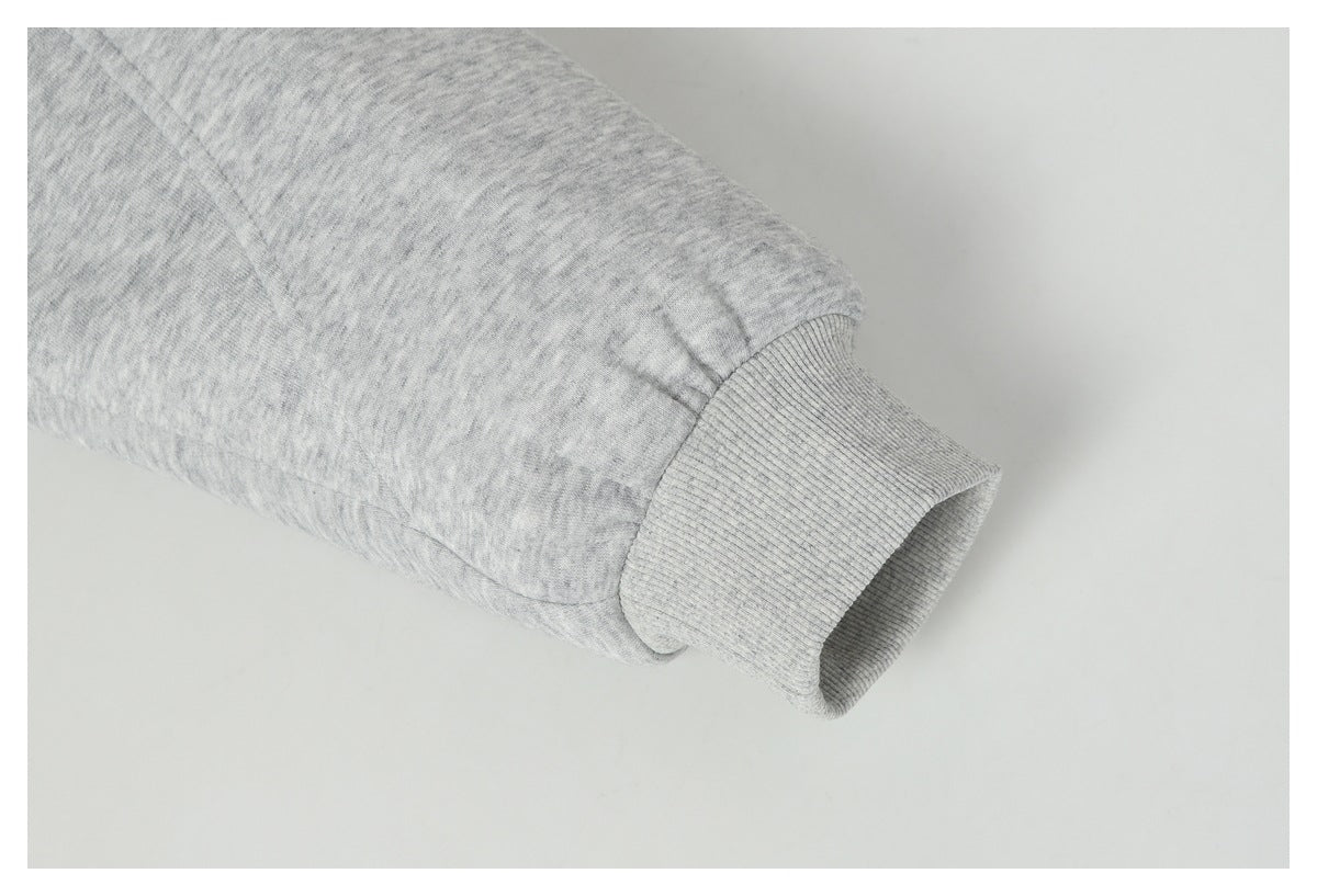 Close-up of a light gray heather sleeve ending in a ribbed cuff.