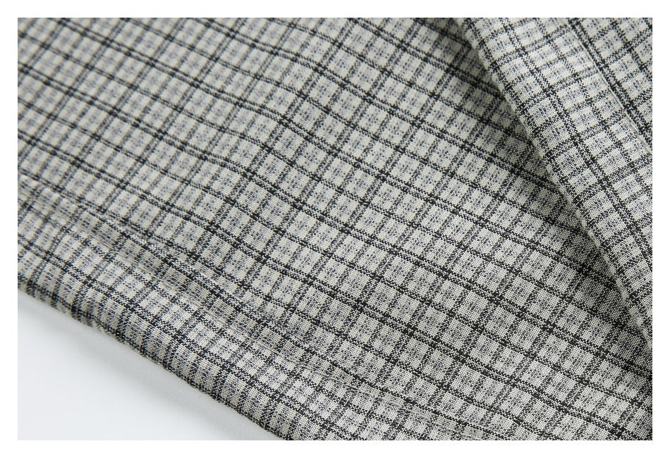 Close-up of textured gray plaid fabric draped in soft folds.