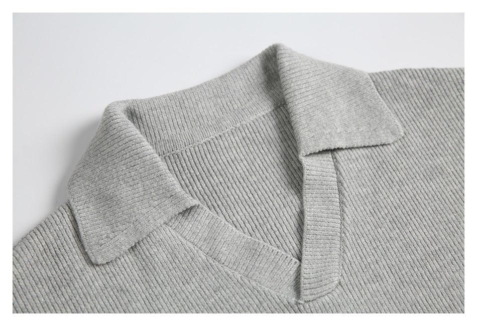 Close-up of a light gray ribbed sweater's notched collar and neckline.