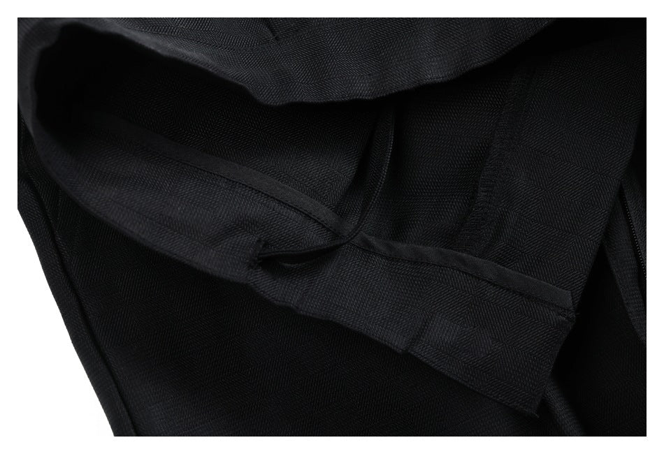 Close-up of the inside of black trouser fabric, showing a folded edge and stitched seams.