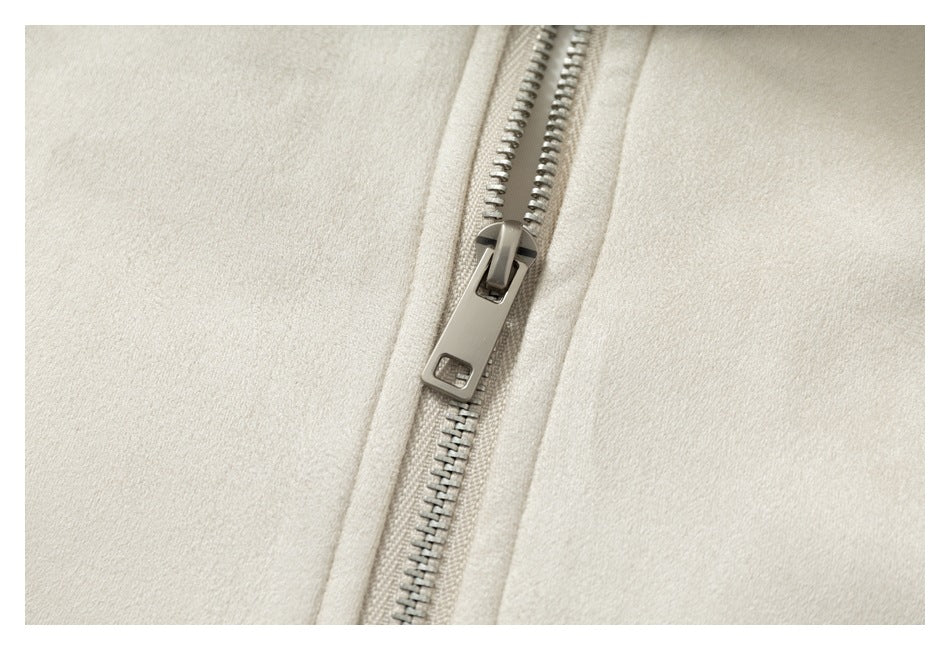 Close-up of the cream jacket's silver zipper and textured fabric.
