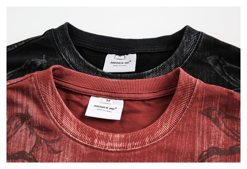 Close-up of black and muted red T-shirt collars and neck labels reading ANSWER ME and MADE IN CHINA.