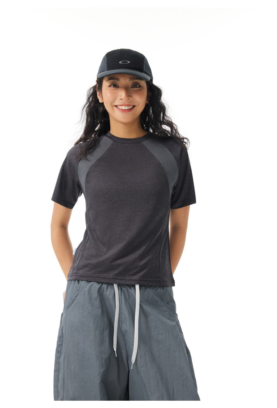 Front view of a model in a charcoal raglan T-shirt and loose slate-gray drawstring pants.