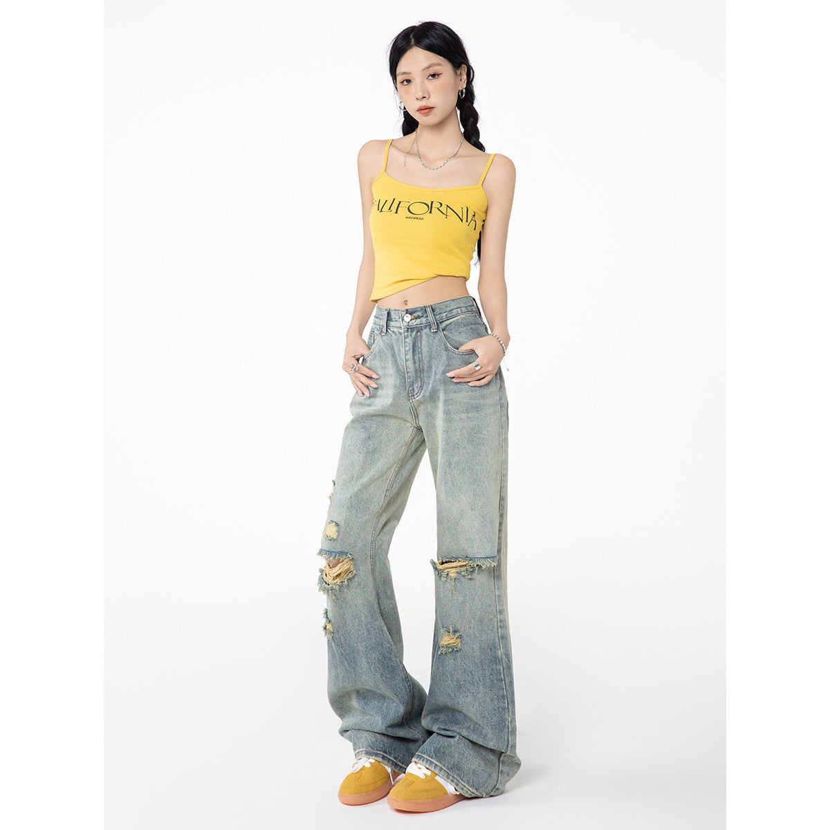 Model wearing a yellow CALIFORNIA-print camisole, distressed light-wash wide-leg jeans, and yellow sneakers.