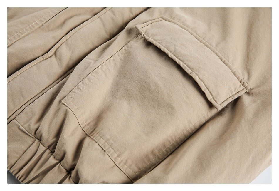 Close-up of a large flap pocket and stitching on the tan jacket.