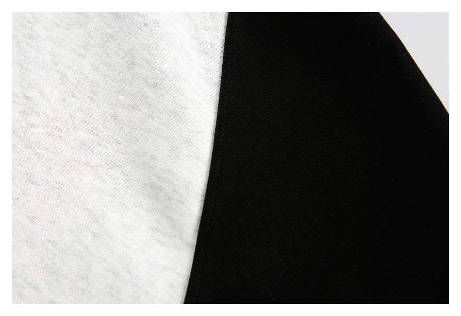 Close-up of a seam between heather-gray and black panels on a color-block garment.