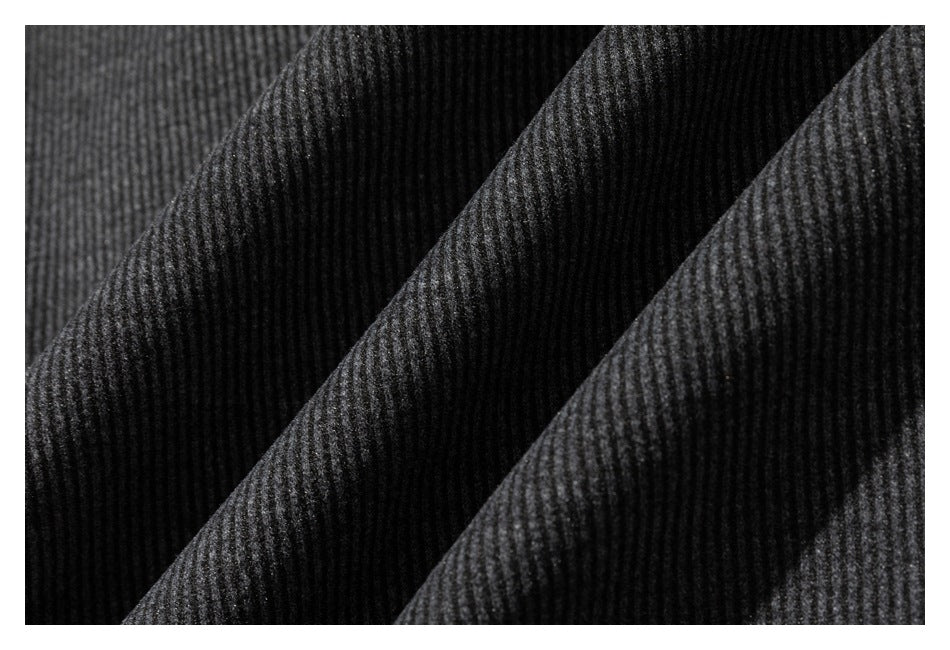 Close-up of dark gray ribbed fabric folded into diagonal ridges.