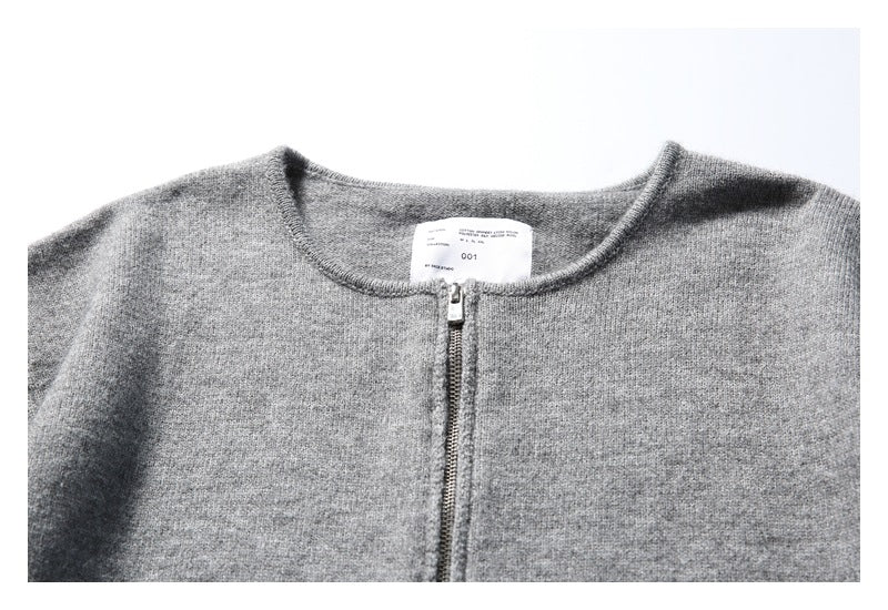 Close-up of the gray knit top's round neckline, front zipper, and sewn-in label.