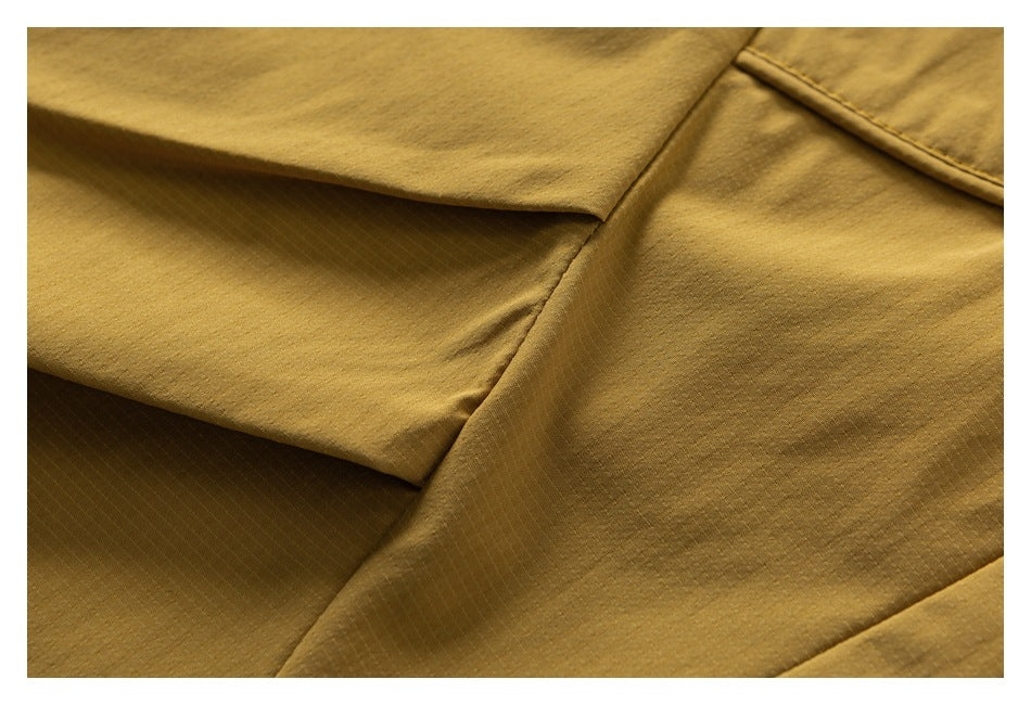 Close-up of the mustard pants fabric and stitched panel seams.