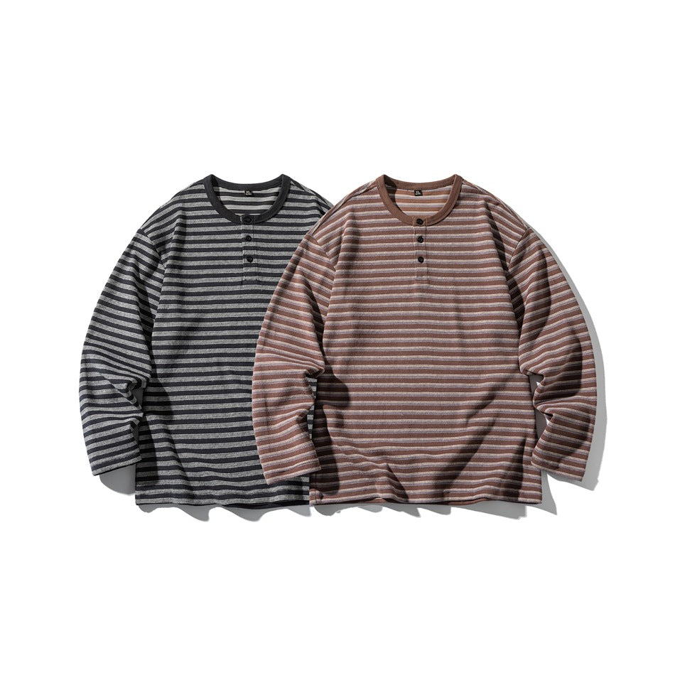 Two long-sleeve striped henleys laid flat: one black and gray, the other brown and gray.