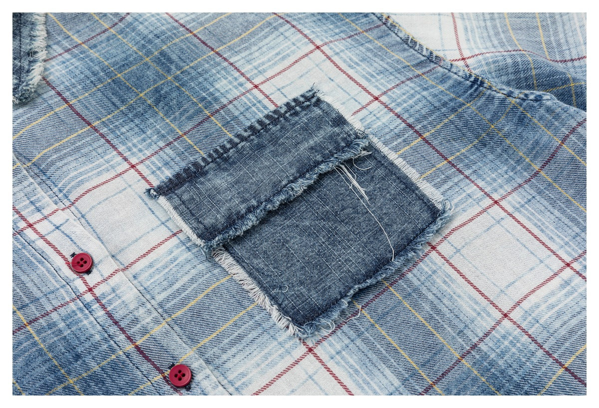 Close-up of the shirt's dark denim patch pocket with frayed edges on blue-and-white plaid fabric.