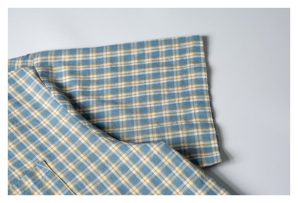Close-up of the short sleeve and cuff on the blue, white, and mustard plaid shirt.