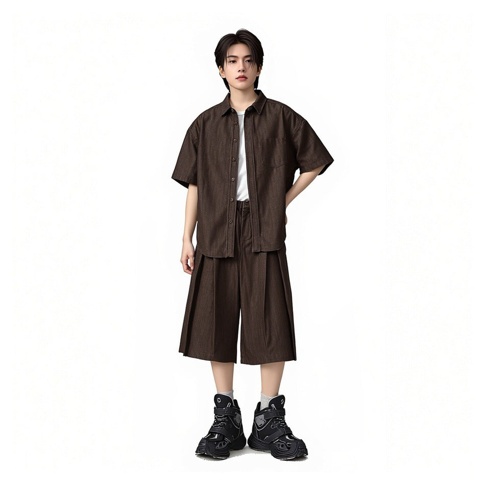 Full-length view of a model wearing a dark brown short-sleeve button-up shirt and matching wide cropped pants.