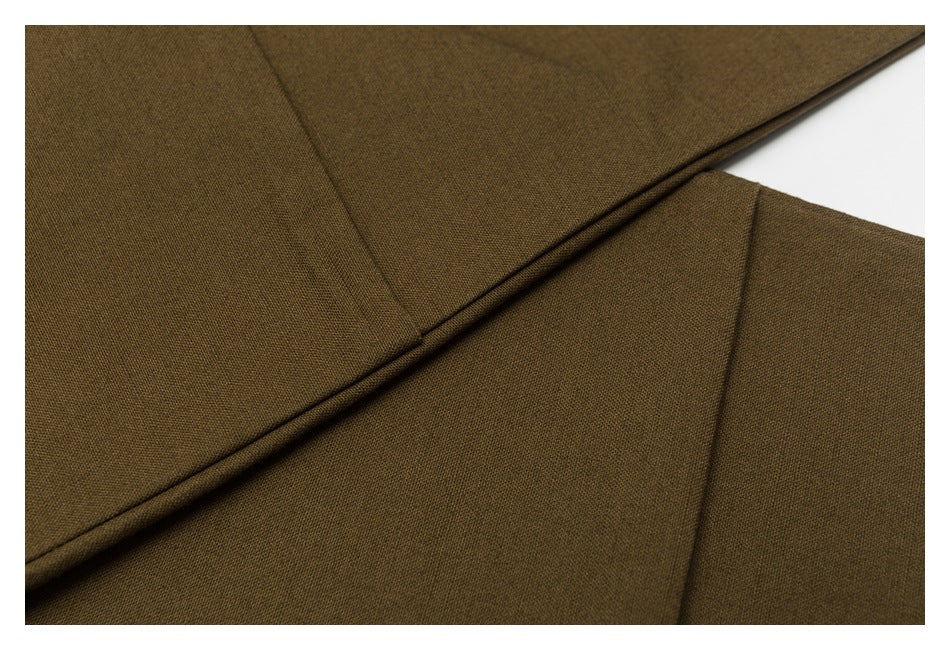 Close-up of dark olive-brown garment fabric with a raised stitched seam.