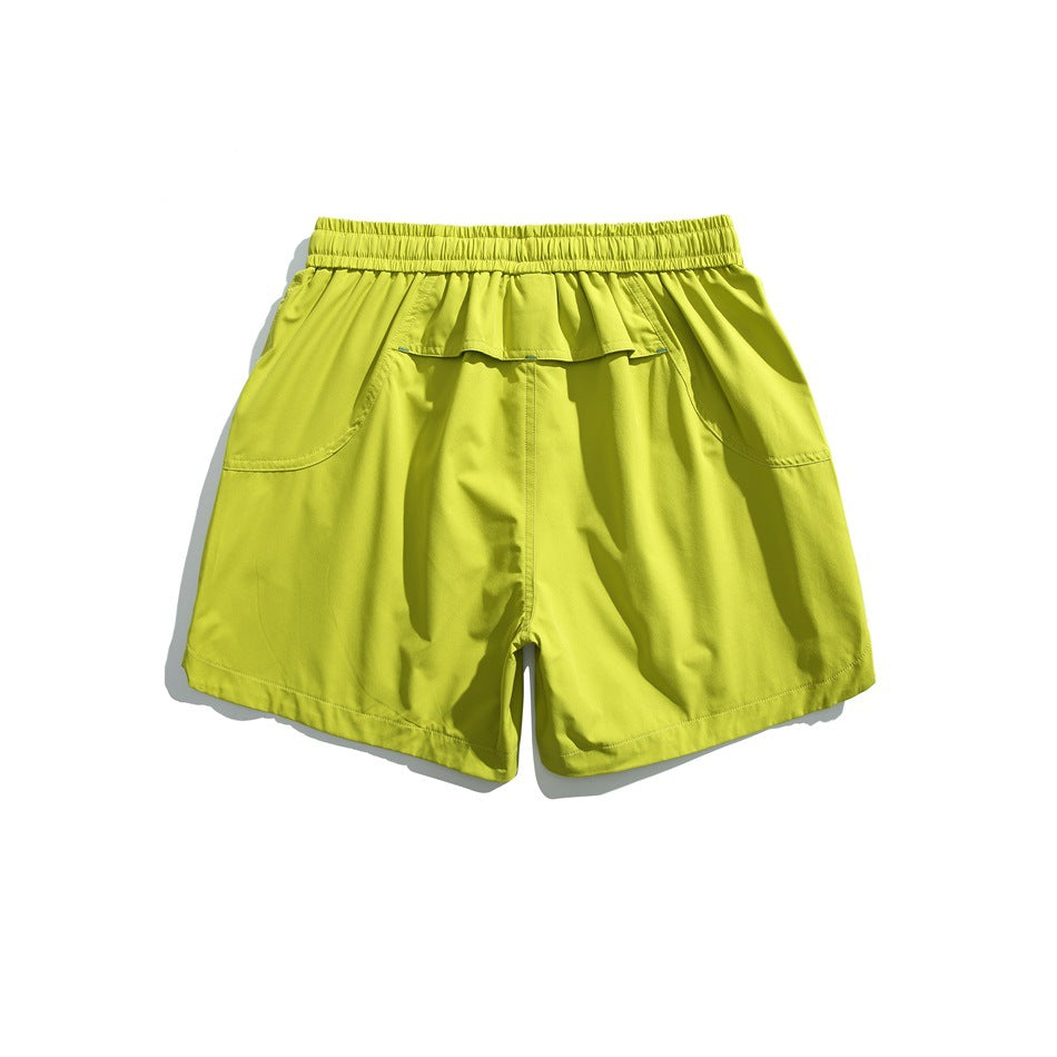 Bright yellow-green athletic shorts shown from the back, with an elastic waistband, flap pocket, and curved side pockets.