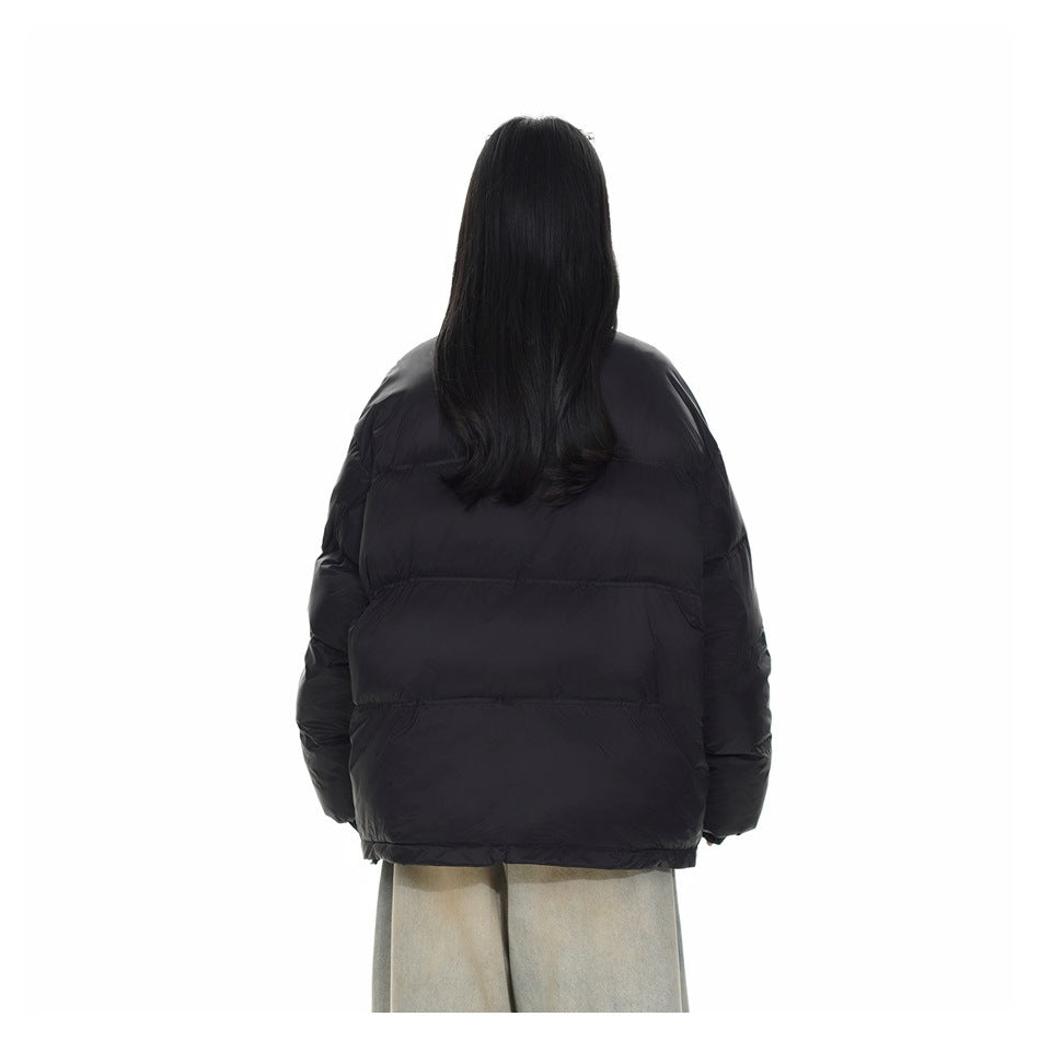 Back view of a model wearing a black puffer jacket with horizontal quilted panels.