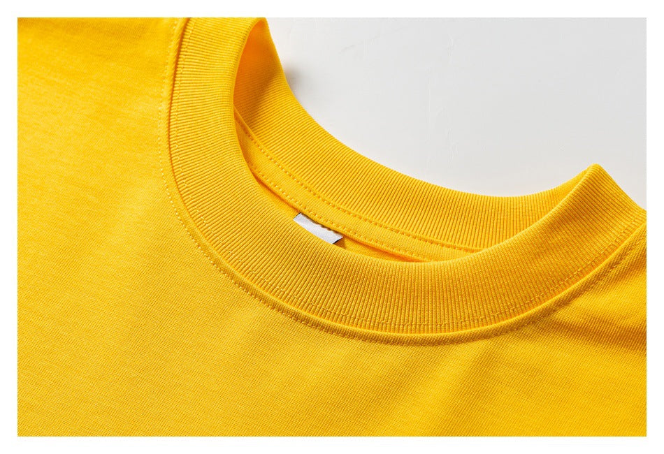 Close-up of the yellow T-shirt's ribbed crew neckline and stitching.