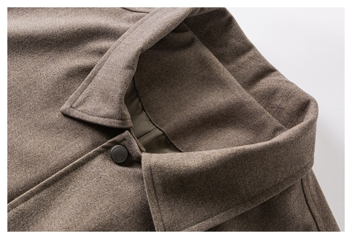 Close-up of a brown textured coat collar, lapel, and dark button.