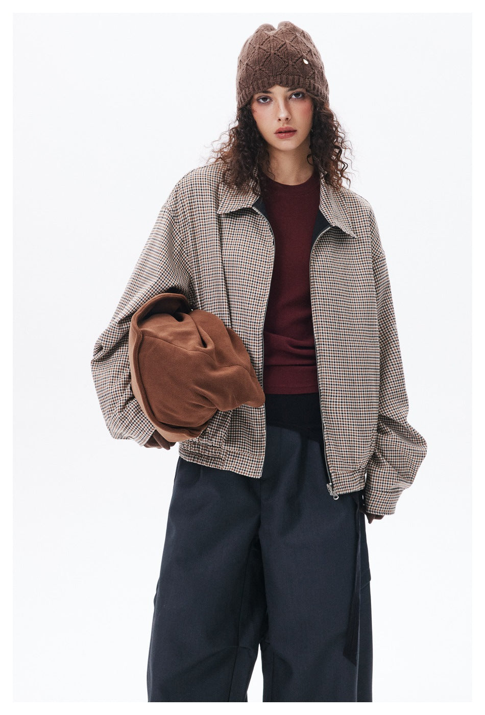Close-up of model in the oversized houndstooth zip jacket with the black reverse side visible at the collar