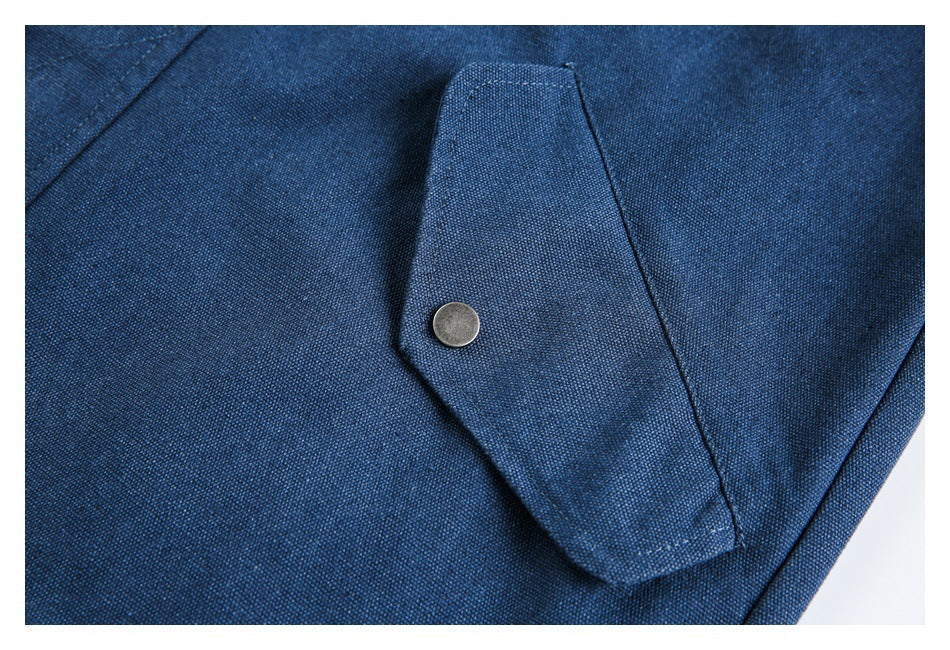 Close-up of a dark blue garment flap secured with a round metal snap.