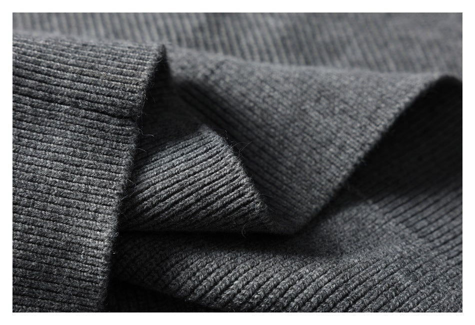 Macro view of the gray knit's ribbed texture and folded fabric.