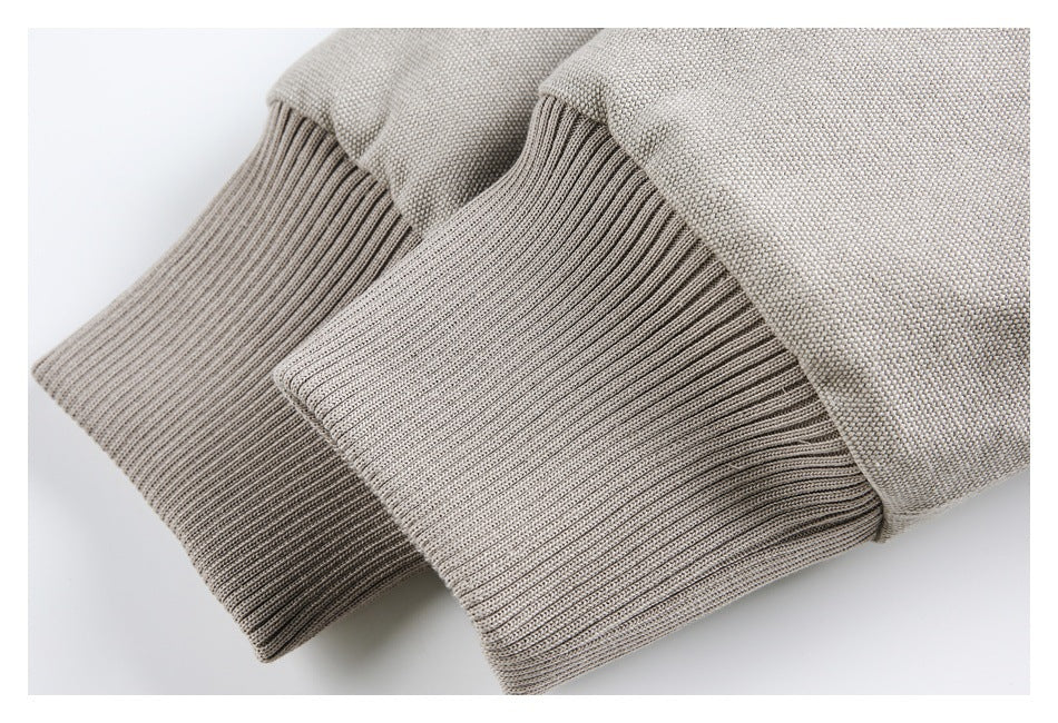 Close-up of the taupe jacket's rib-knit cuffs and textured woven body.