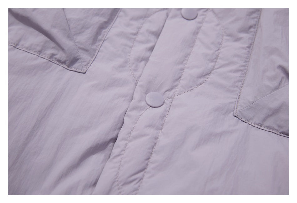 Close-up of lavender snap buttons, the front placket and quilted stitching.
