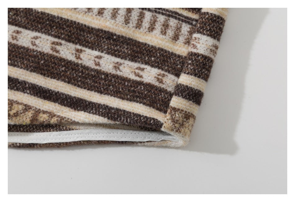 Close-up of the hem and stitched edge of brown, cream, and tan striped fabric.