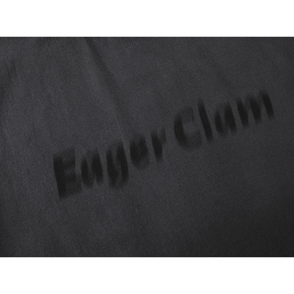 Close-up of subtle black lettering printed diagonally across charcoal shirt fabric.