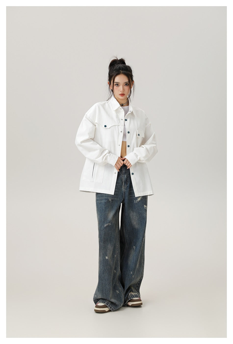 Model wearing a white oversized button-front shirt with flap chest pockets and lower patch pockets.
