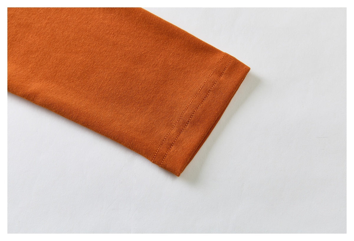 Close-up of a rust-orange sleeve cuff with double-row stitching.