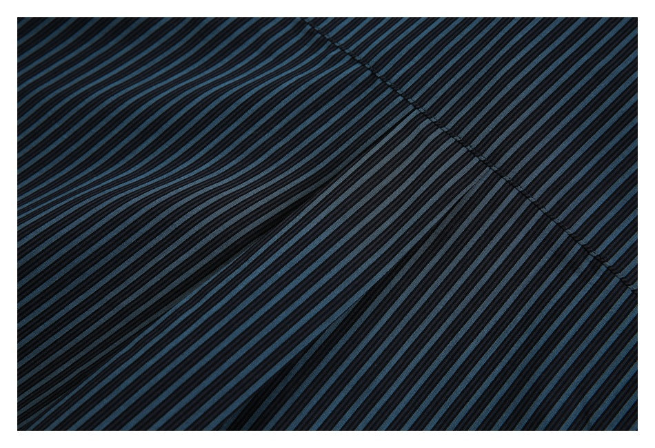 Close-up of dark blue-and-black striped fabric with a diagonal stitched seam.