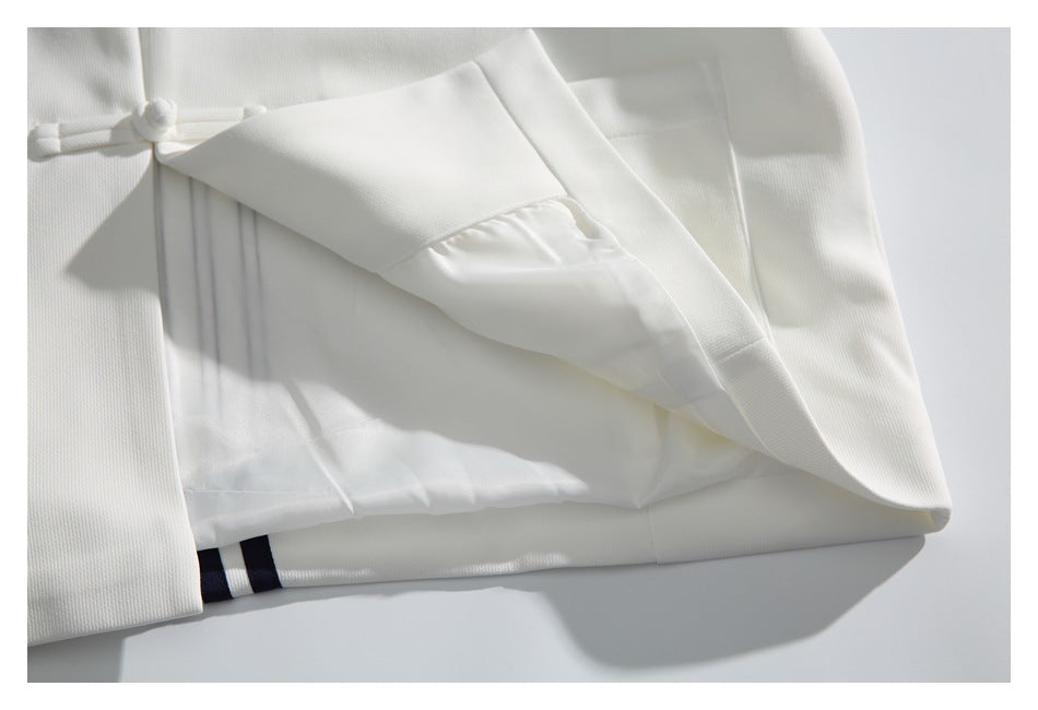 The white jacket is opened to show its smooth inner lining and a narrow navy-and-white striped detail.