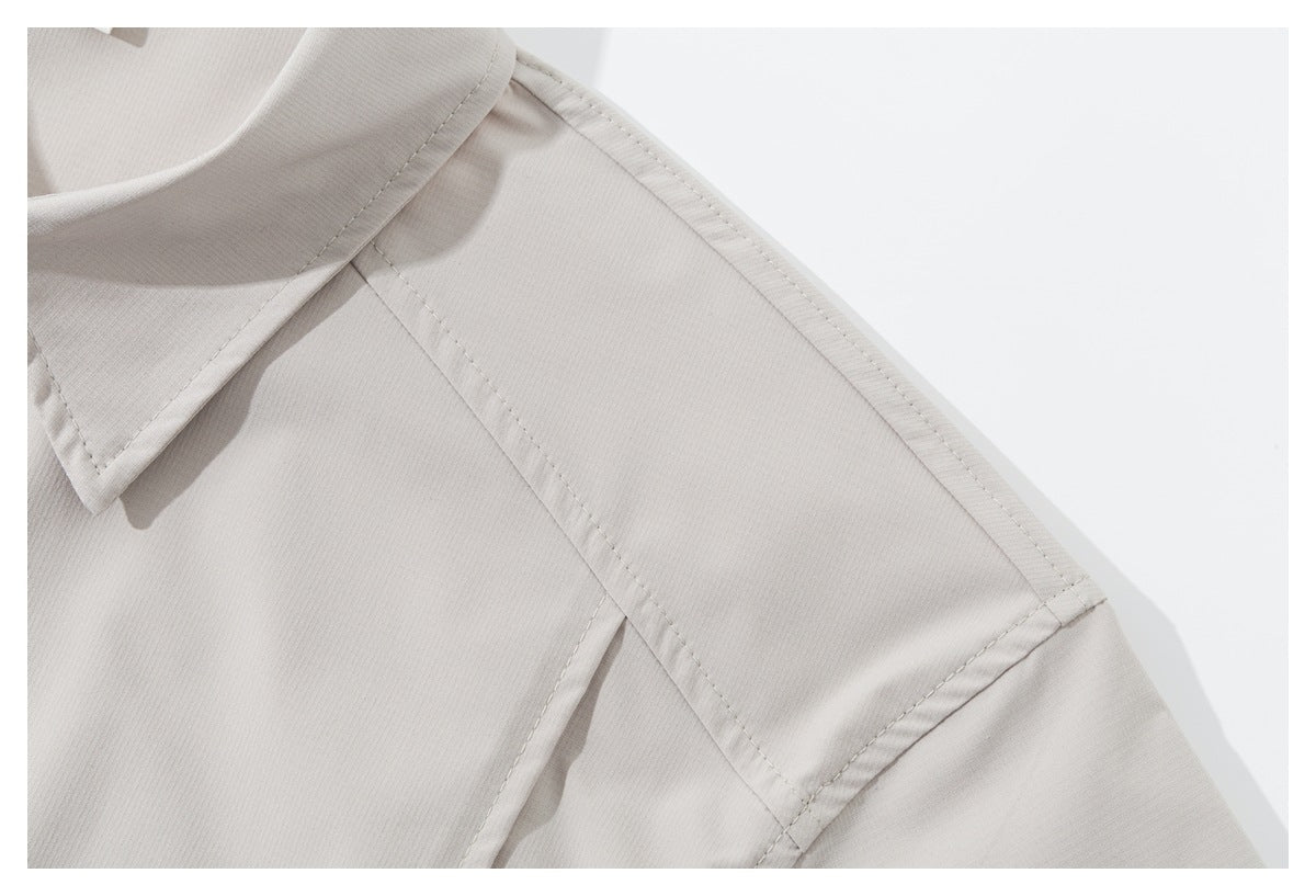 Close-up of the light beige shirt's collar, shoulder seam, and stitching.