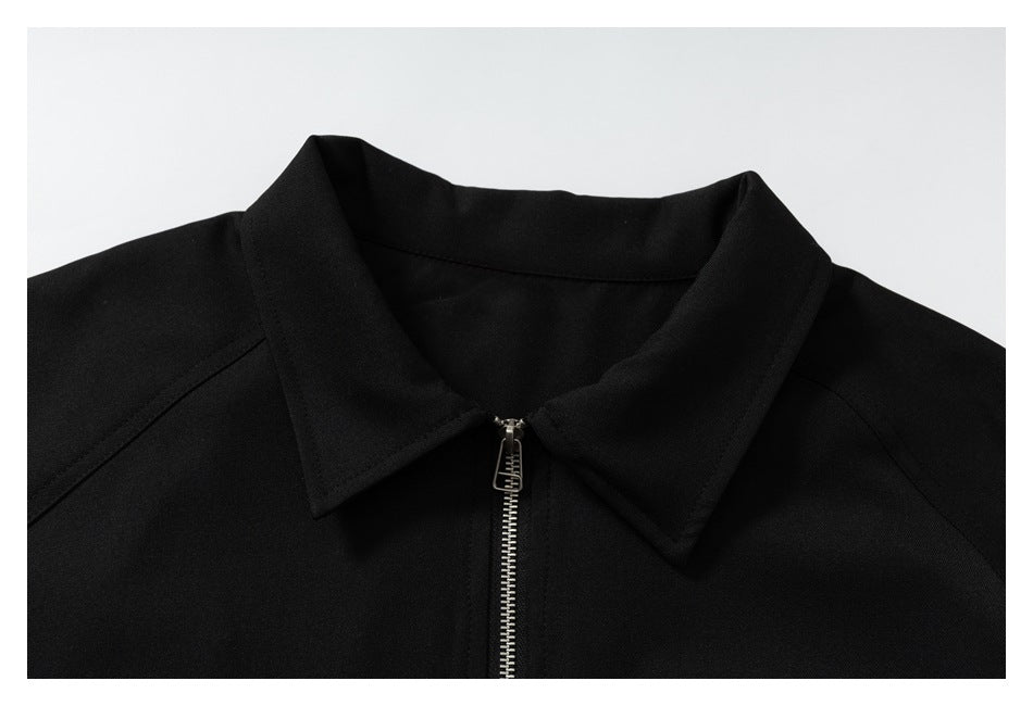 Close-up of the black jacket's pointed collar and silver front zipper.