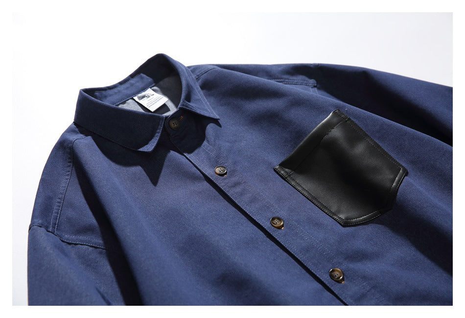 Navy button-up shirt laid at an angle, showing its collar, dark buttons and black chest pocket.