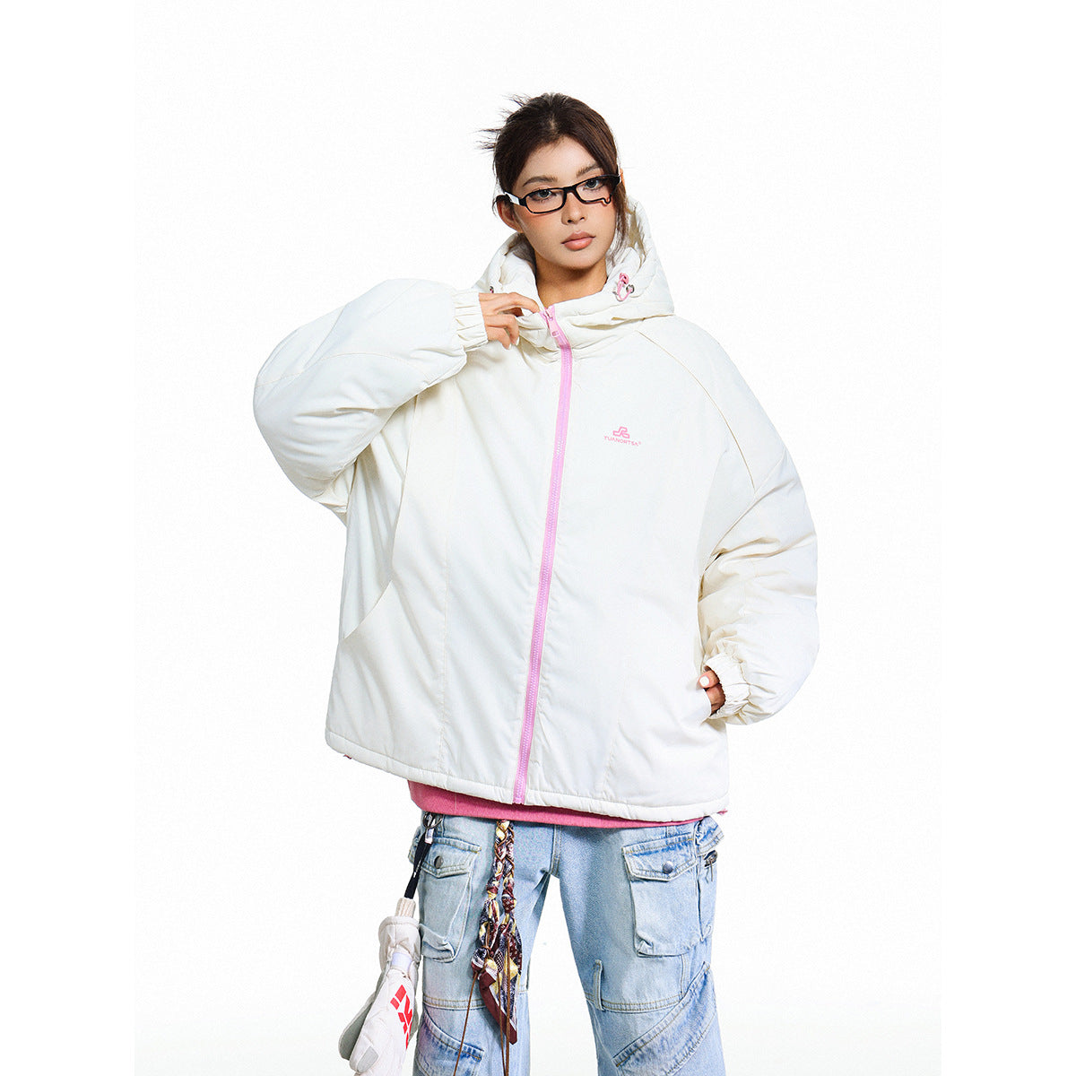 Model wearing a white oversized hooded jacket with a pale pink zipper, paired with light blue cargo jeans.
