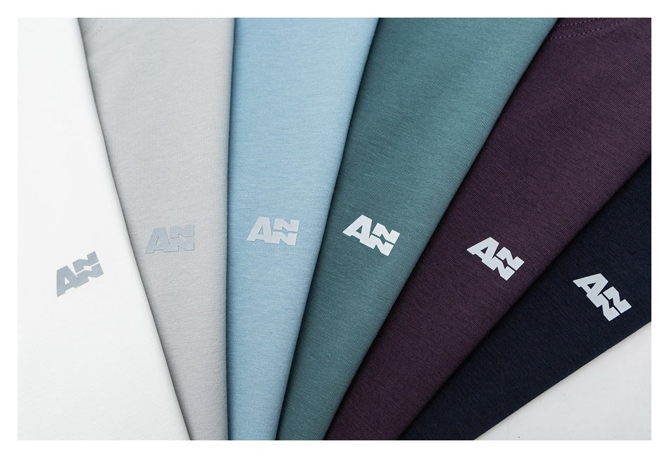 Close-up of six T-shirt color options fanned out, each with a small light-colored logo on the fabric.