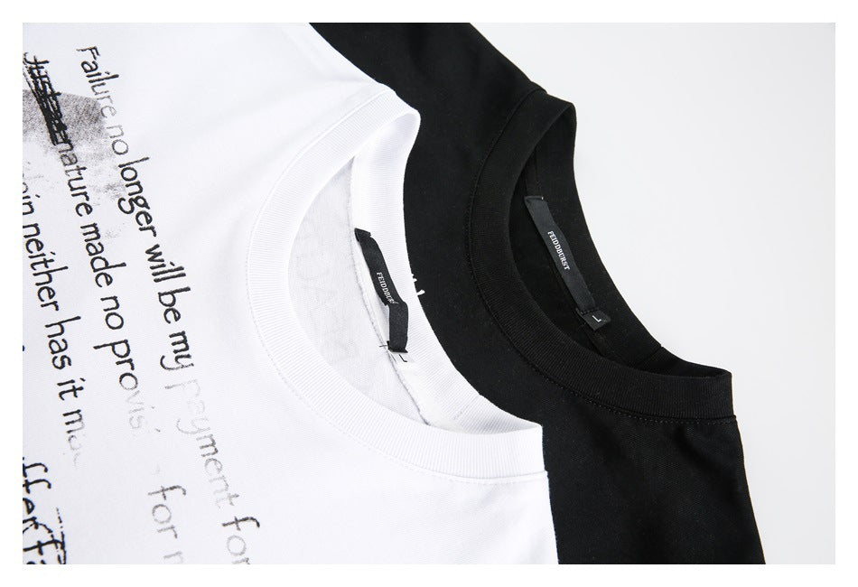Close-up of white and black crewneck T-shirts, showing their collars and English text print on the white shirt.