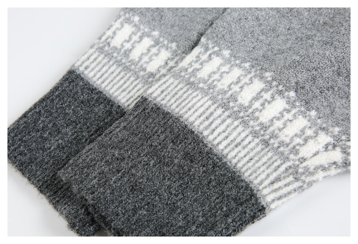 Close-up of a dark charcoal ribbed knit edge beneath a cream geometric band on gray knit.
