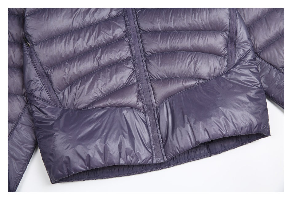 Close view of the quilted jacket's lower front, angled zipper pockets, and hem.
