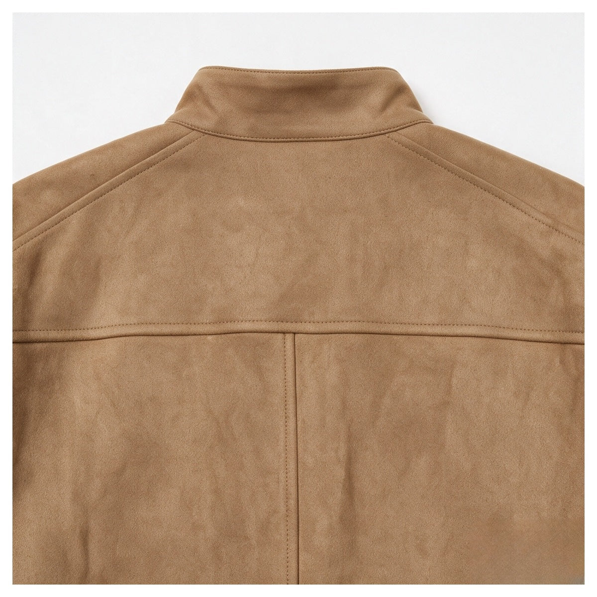 Close-up of the camel-brown jacket’s back, showing the stand collar, shoulder seams, and yoke stitching.