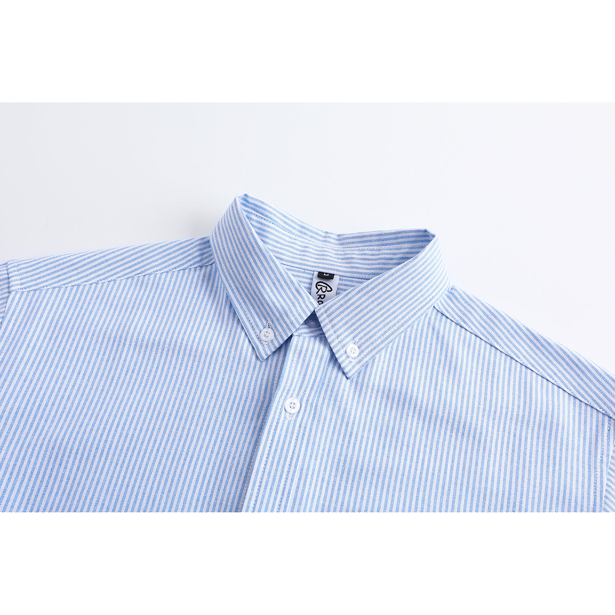 Close-up of a light blue and white striped shirt collar with button-down points and a white neck label.