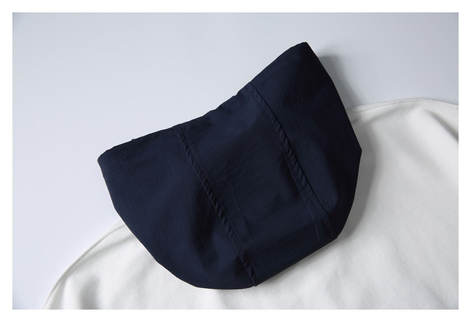 Close-up of a dark navy hood or collar panel resting on a white garment.