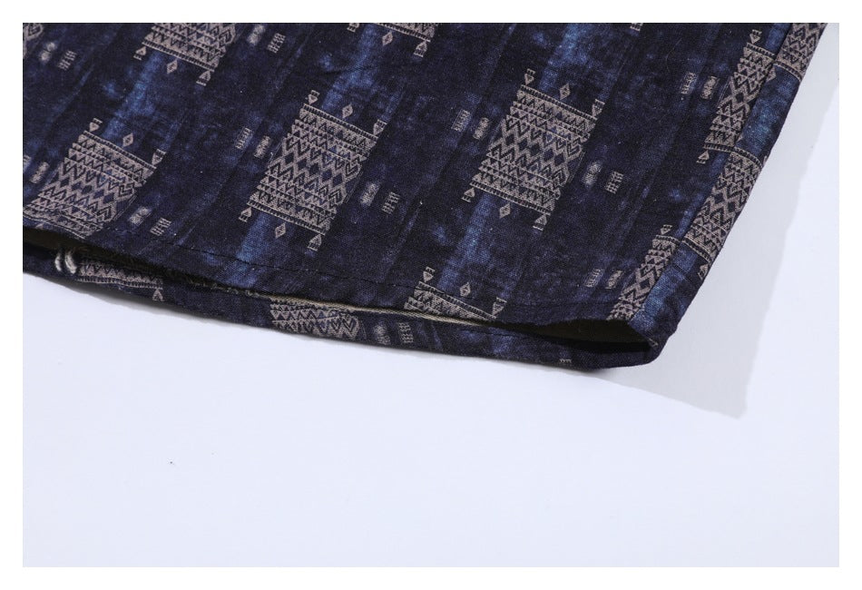 Close-up of a dark navy garment hem with repeating tan geometric motifs.