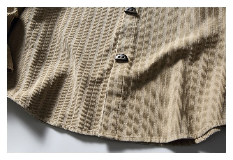 Close-up of the tan shirt's vertically textured front, dark buttons and curved hem.