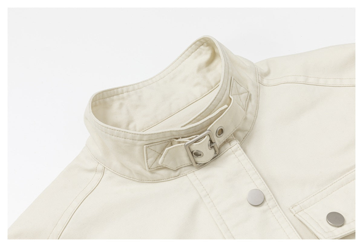 Close-up of the ivory jacket's stand collar, metal buckle tab, stitching, and snap-front closure.
